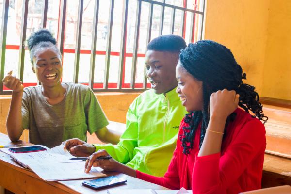 Photo of Nigerian students laughing as they work together in the classroom