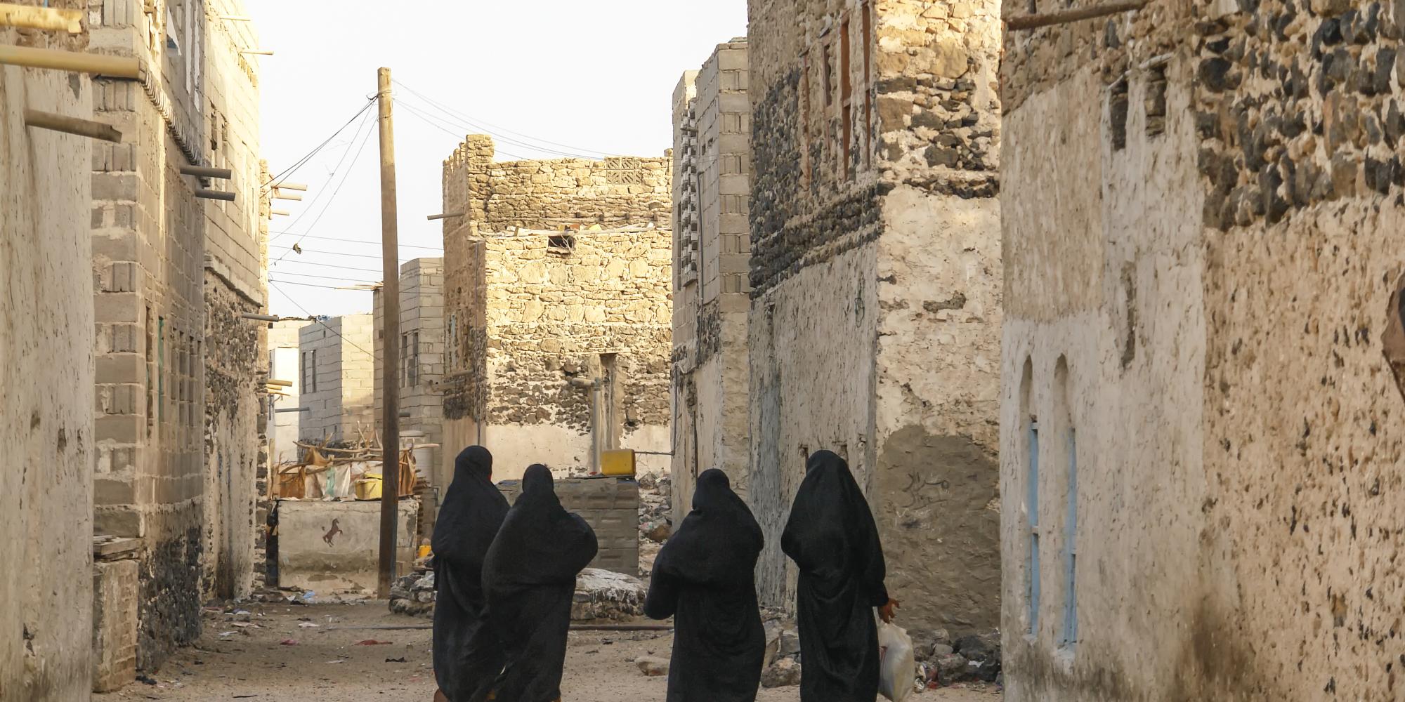 Women walking through Yemeni village, carrying their shopping