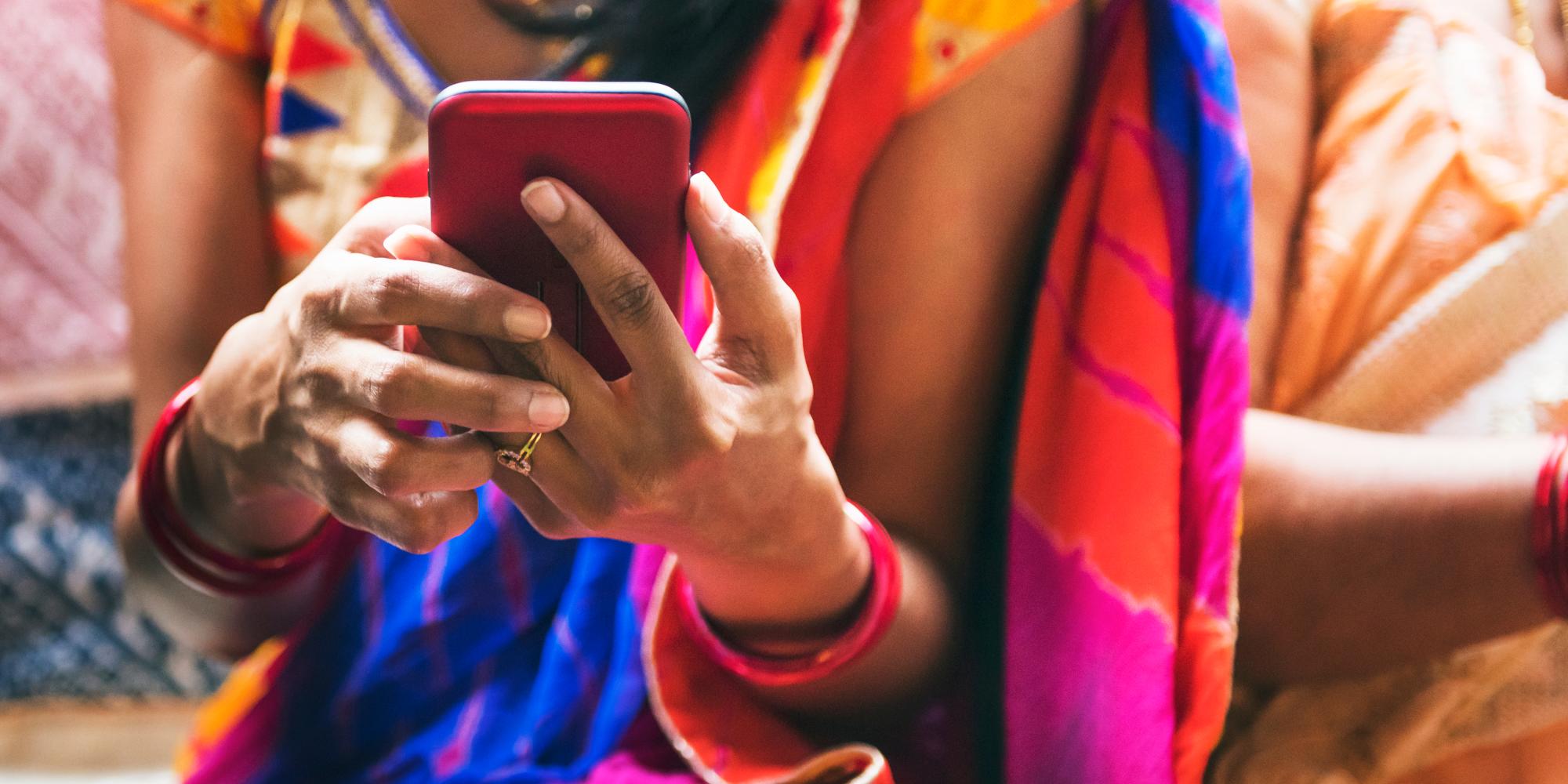Woman dressed in sari uses mobile phone