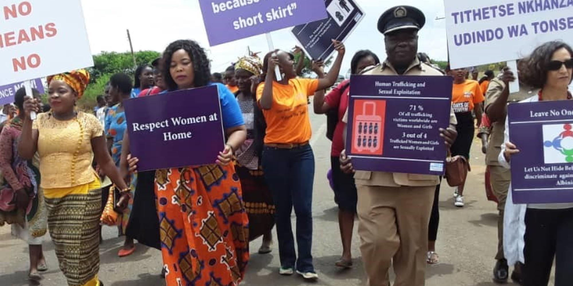 Malawi gender-based violence protest, marching along street with placards