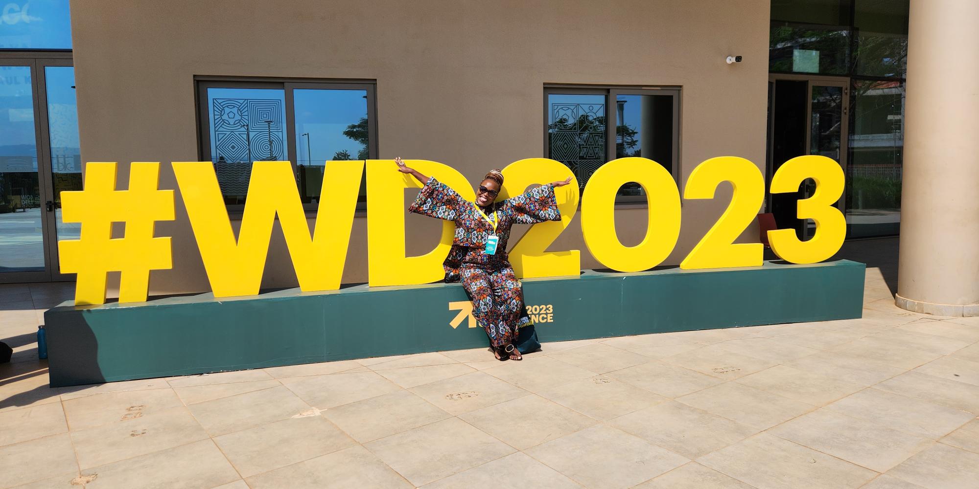 Lusungu Kalanga in front of the Women Deliver conference sign in Kigali. 