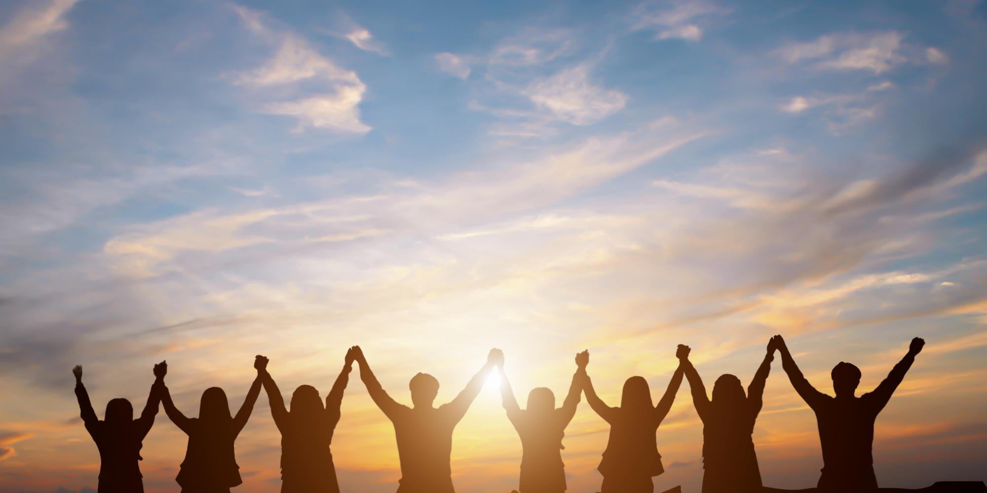 silhouette of people holding hands in the sunset